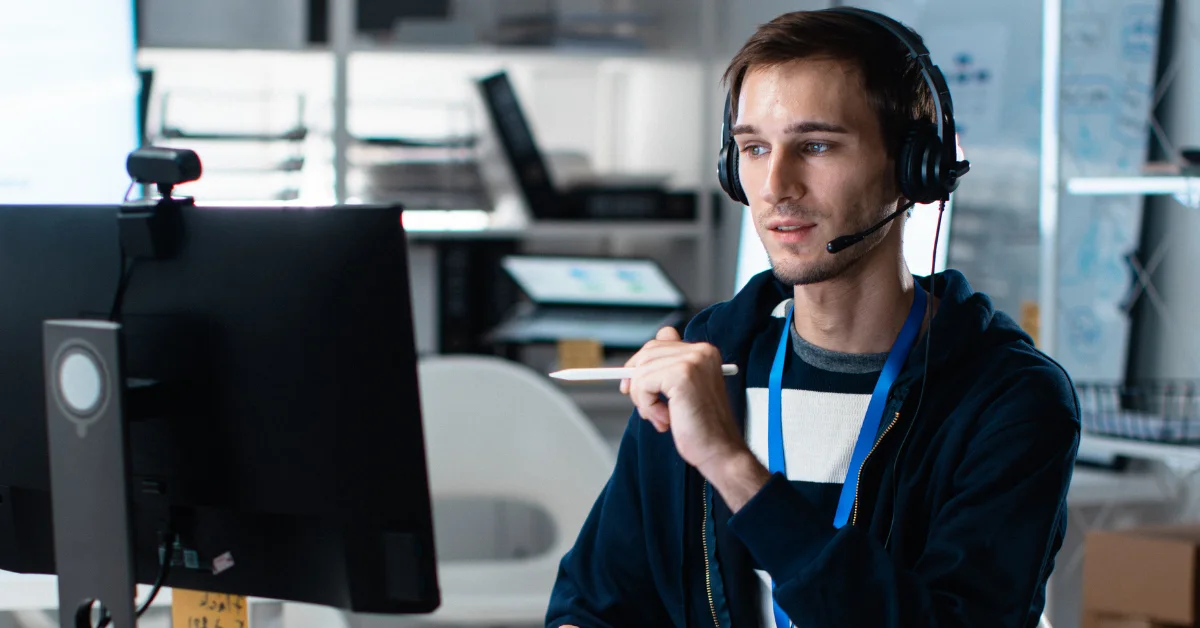 Technician wearing headset holding touch pen in creative office